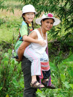 Mother Tomei carrying Robyn over the paddies